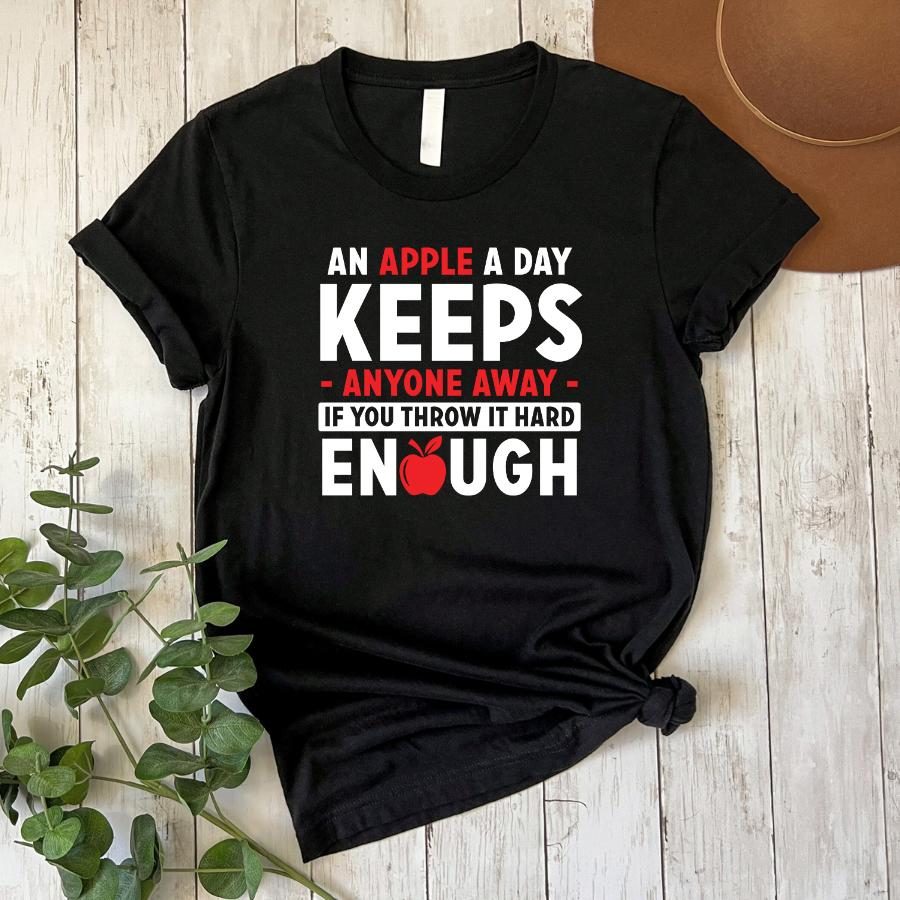 Black t-shirt with humorous "An apple a day keeps anyone away if you throw it hard enough" text and red apple graphic