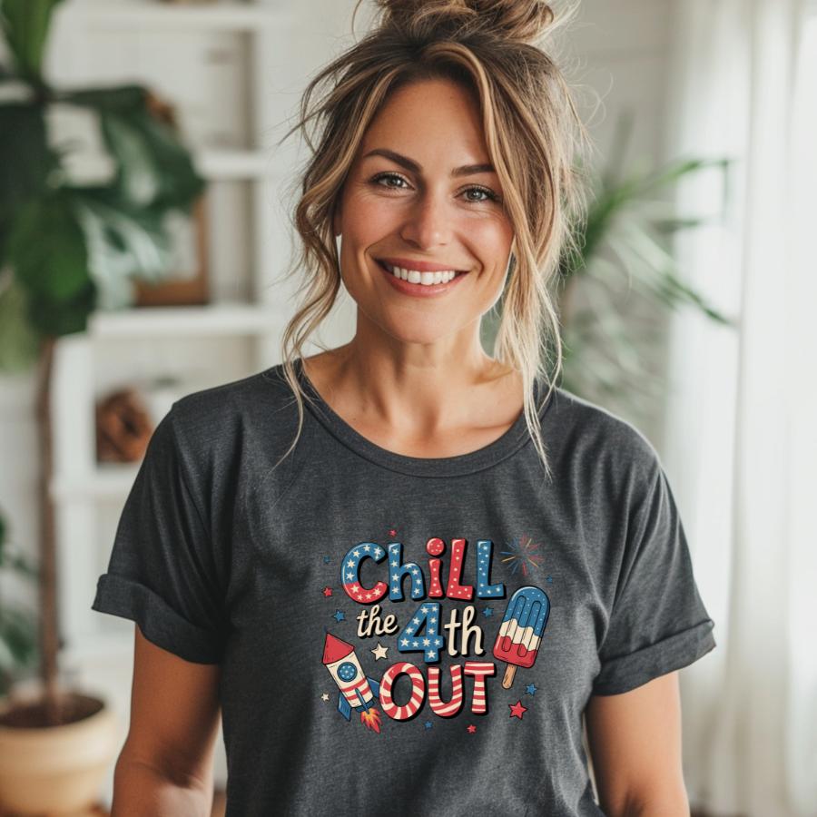 woman wearing a dark gray Chill the 4th Out t-shirt with patriotic fireworks and popsicle design smiling indoors