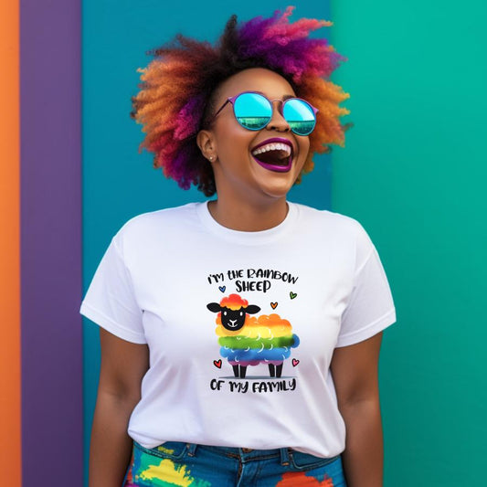 Smiling person with colorful hair wearing a white Rainbow Sheep T-Shirt featuring a rainbow-colored sheep and the text "I'm the Rainbow Sheep of my family" against a vibrant teal background