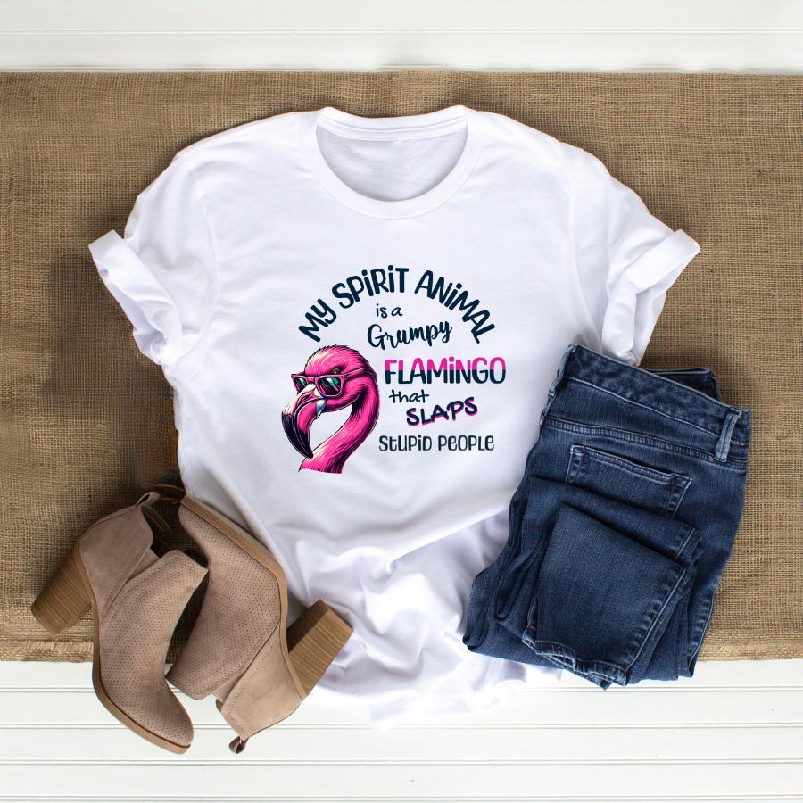 White t-shirt with "My Spirit Animal Is a Grumpy Flamingo that Slaps Stupid People" graphic paired with blue jeans and brown ankle boots.