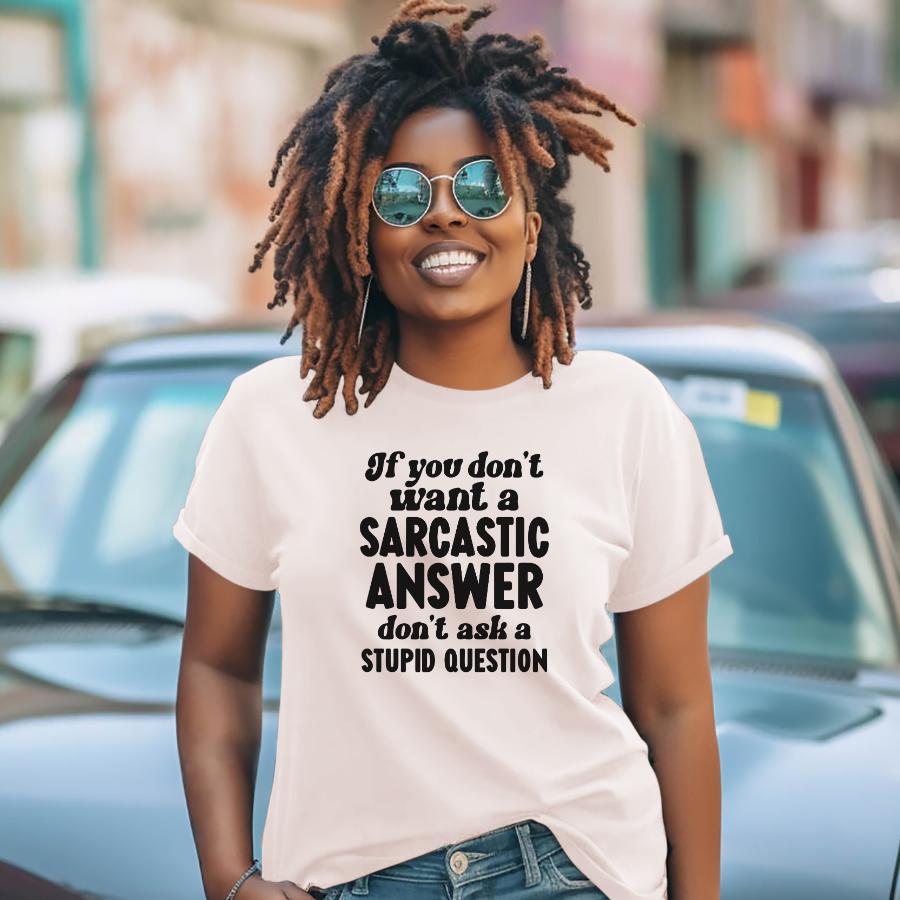 Woman wearing white t-shirt with sarcastic answer quote and sunglasses smiling outdoors