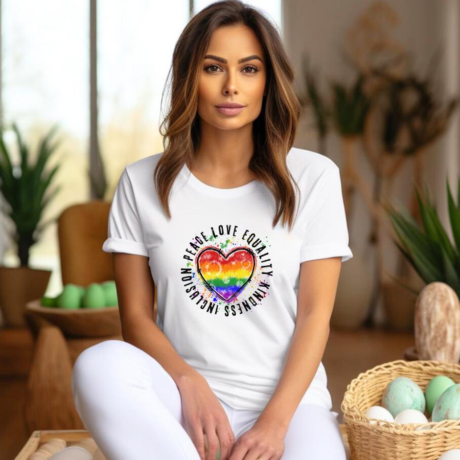 Woman wearing white t-shirt with rainbow heart and words Peace Love Equality Kindness Inclusion around it