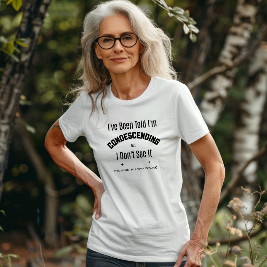 Woman wearing white "I've Been Told I'm Condescending but I Don't See It" T-shirt with glasses outdoors