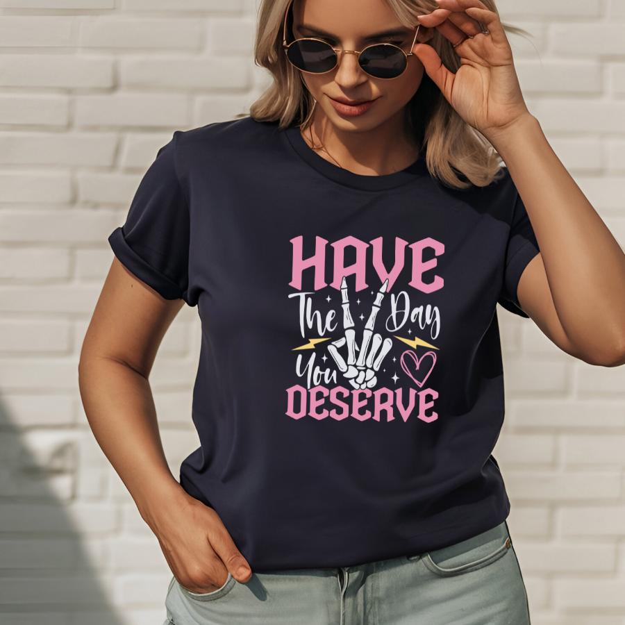 Woman wearing navy blue Have the Day You Deserve T-shirt with graphic design and sunglasses