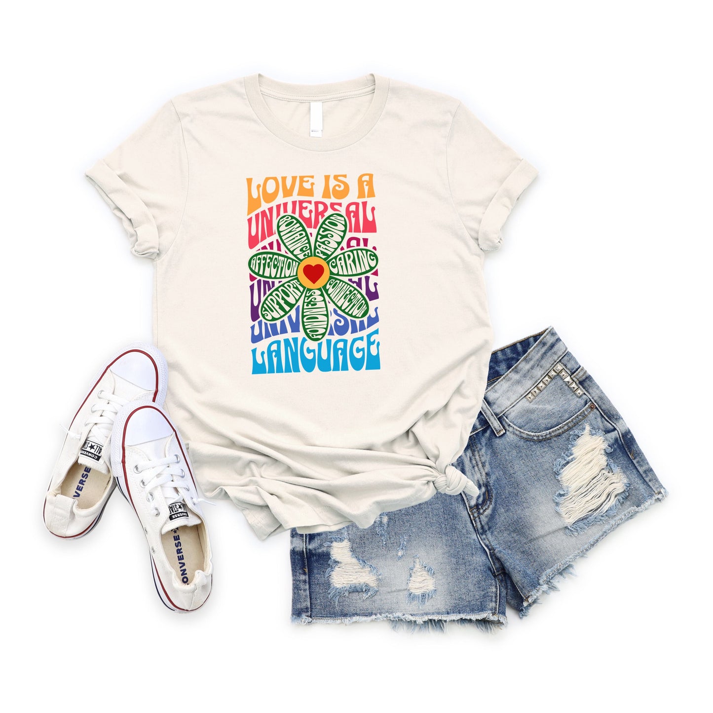 Love is a Universal Language T-Shirt with colorful flower design, paired with denim shorts and white sneakers