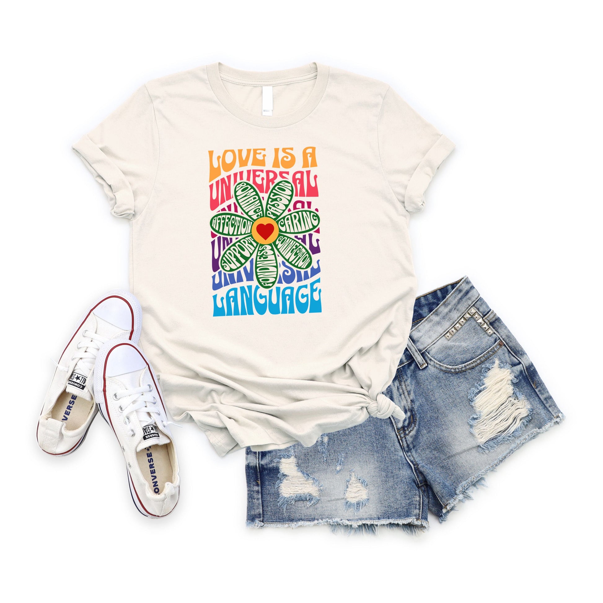 Love is a Universal Language T-Shirt with colorful flower design, paired with denim shorts and white sneakers