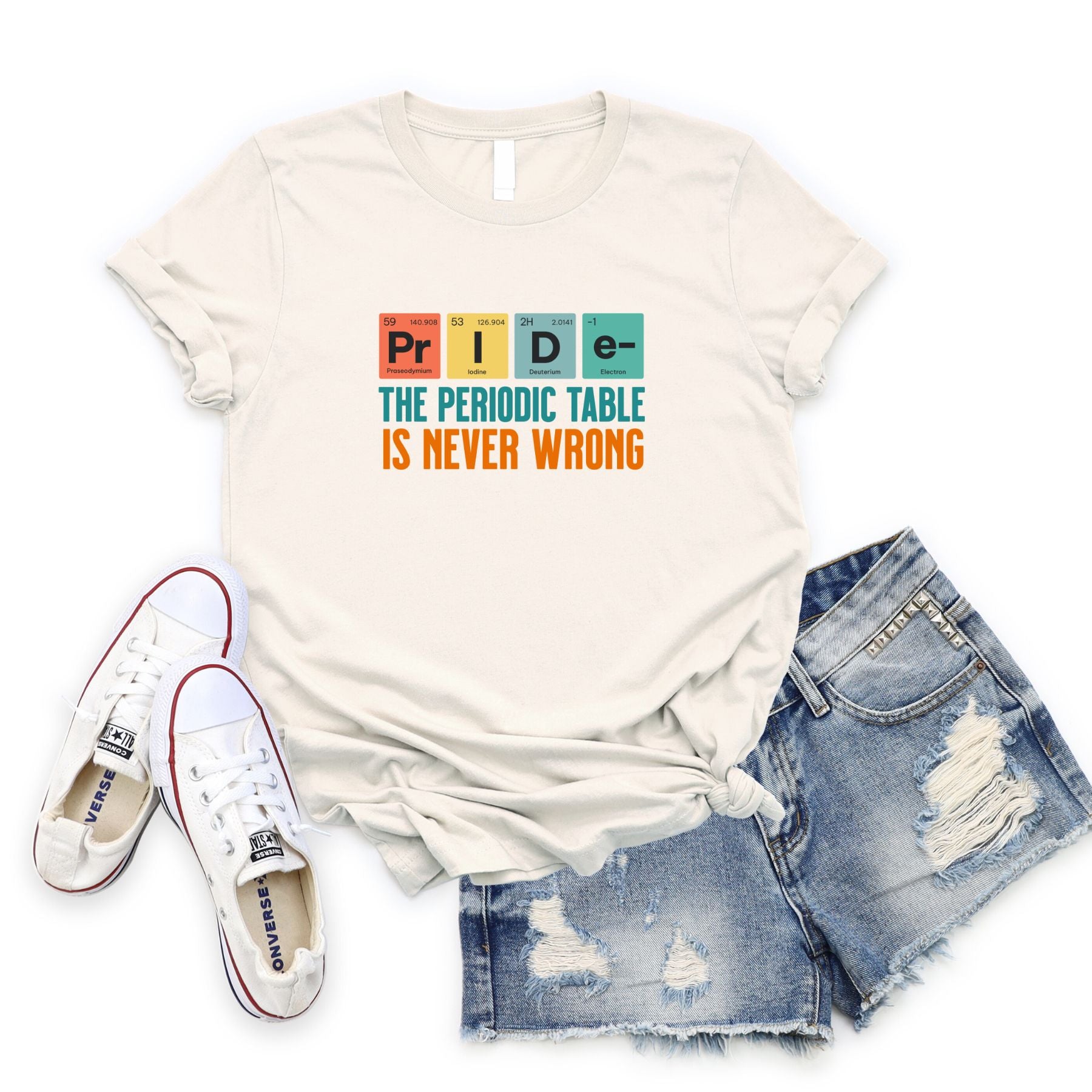 White t-shirt with "The Periodic Table is Never Wrong" text and pride-themed periodic table elements, paired with ripped denim shorts and white sneakers