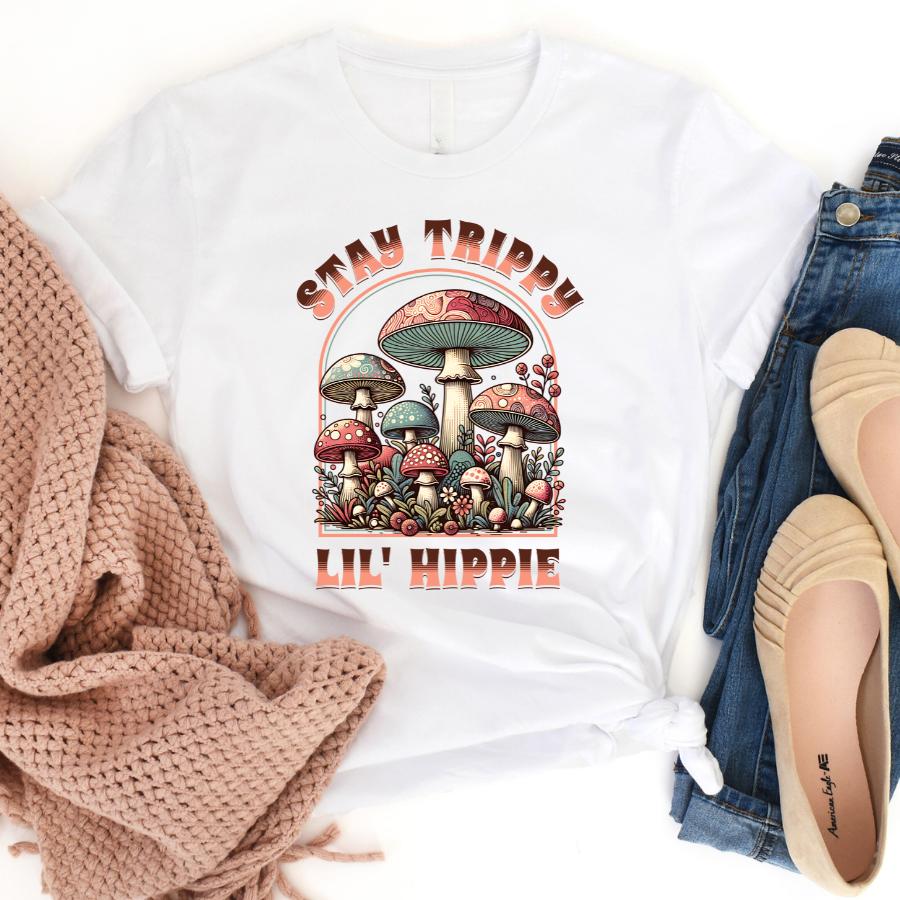 White Stay Trippy Lil' Hippie T-shirt with colorful psychedelic mushroom graphic and retro text design